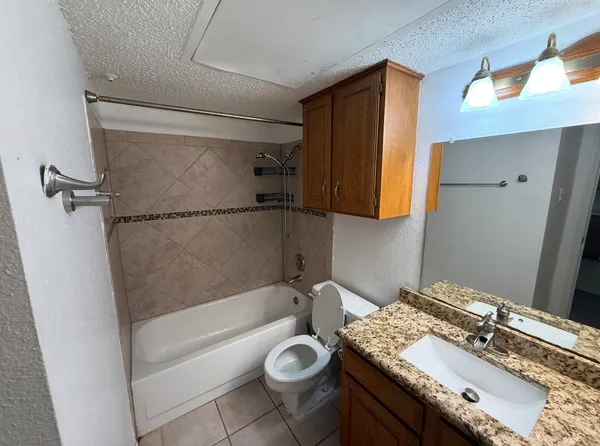 a bathroom with a granite countertop sink toilet and shower