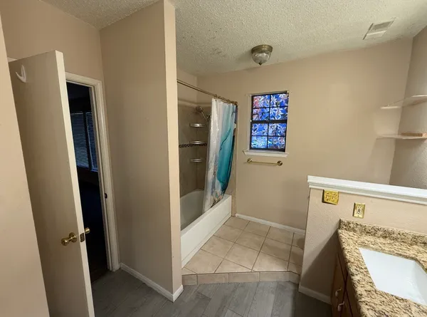 a bathroom with a granite countertop toilet sink and mirror