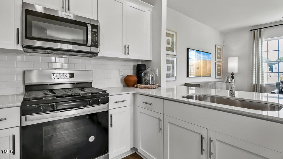 5207 Red Crimson Drive Willow Spring, NC 27592 - Photo 5 of 29 a kitchen with stainless steel appliances a stove a microwave a sink and cabinets