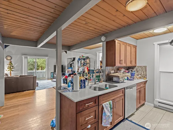 a kitchen with stainless steel appliances wooden cabinets a dining table and chairs with wooden floor