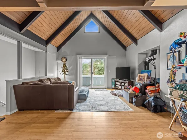 a living room with furniture a flat screen tv and a refrigerator