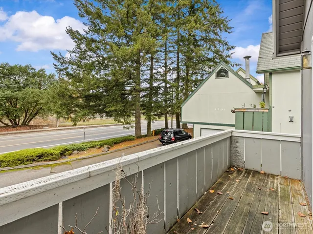a view of a balcony with wooden floor and fence