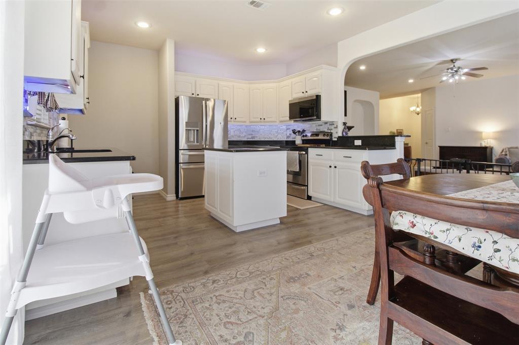 10928 Middleglen Road Fort Worth, TX 76052 - Photo 12 of 37 a kitchen with refrigerator a stove and chairs