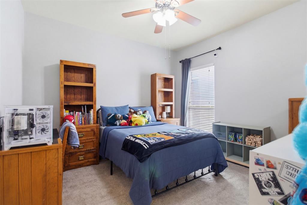 10928 Middleglen Road Fort Worth, TX 76052 - Photo 22 of 37 a bedroom with a bed and a dresser in it