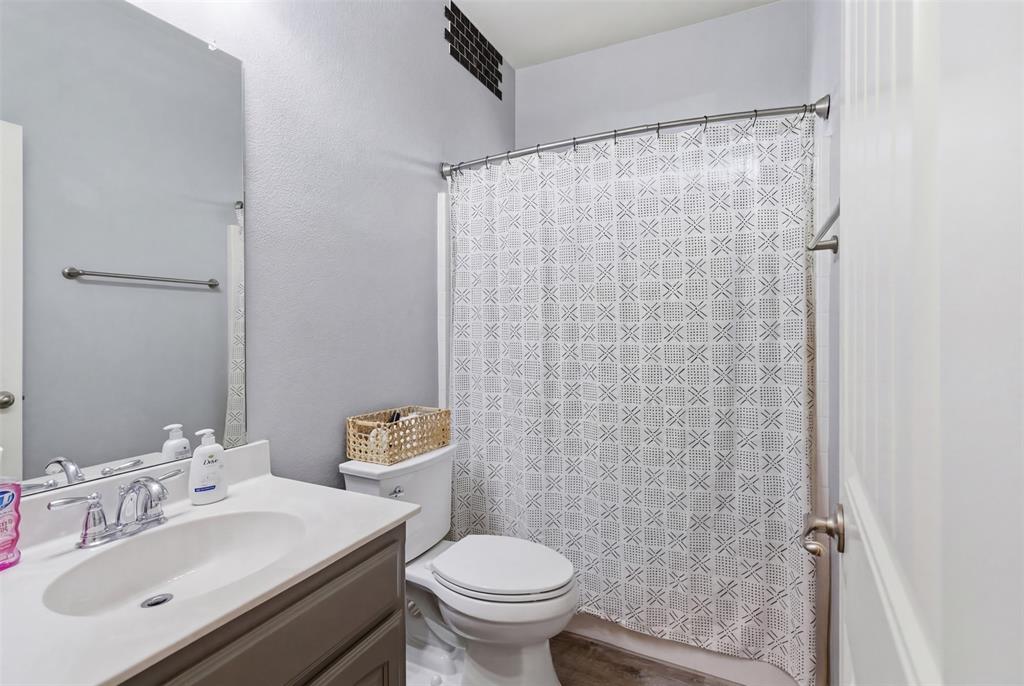 10928 Middleglen Road Fort Worth, TX 76052 - Photo 25 of 37 a bathroom with a sink a toilet and shower curtain