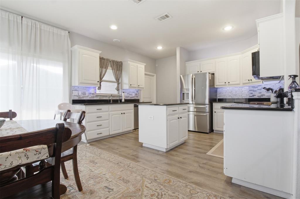 10928 Middleglen Road Fort Worth, TX 76052 - Photo 4 of 37 a kitchen with white cabinets and stainless steel appliances
