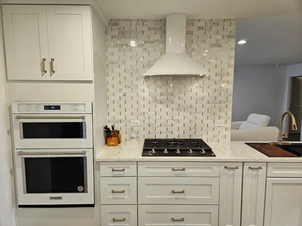 a kitchen with a stove and white cabinets