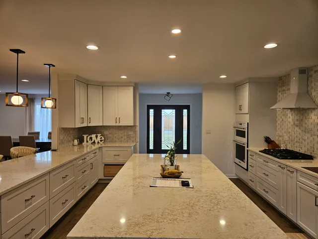 a large kitchen with kitchen island a large counter top space a sink stainless steel appliances and cabinets