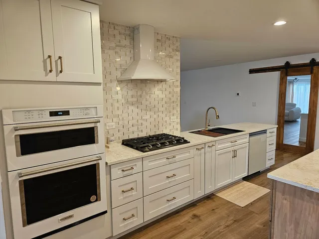 a kitchen with granite countertop white cabinets and white appliances