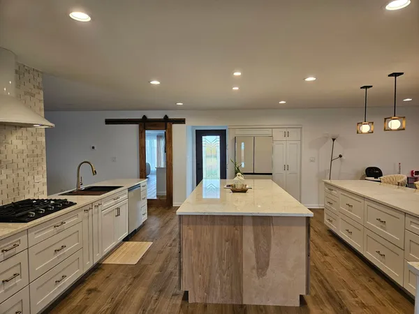 a large kitchen with kitchen island a sink stainless steel appliances and a counter top space