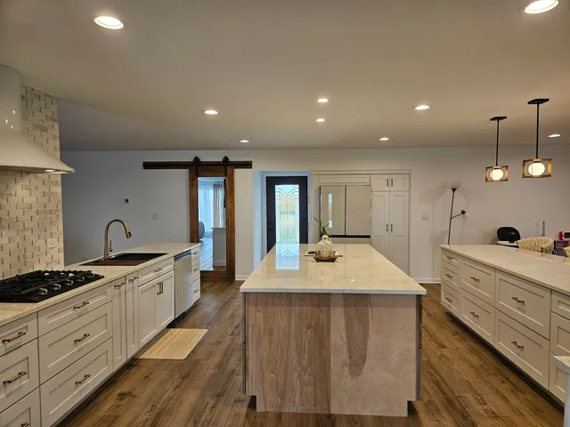 a large kitchen with kitchen island a sink stainless steel appliances and a counter top space