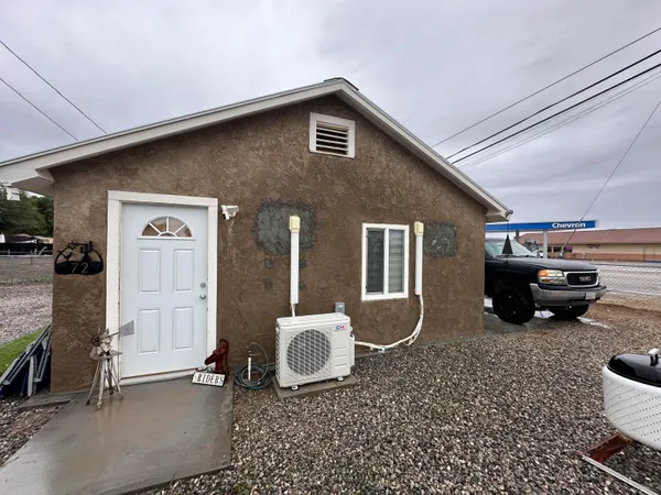 a view of a house with a barbeque and wooden fence