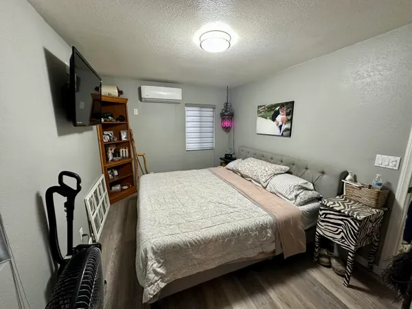 a bedroom with bed and a flat tv screen