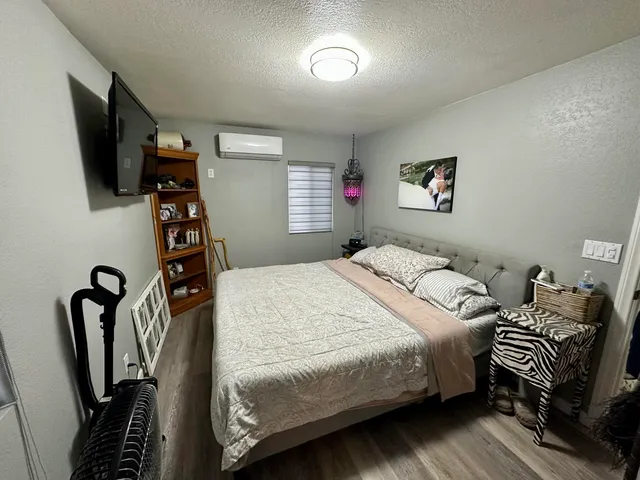 a bedroom with bed and a flat tv screen