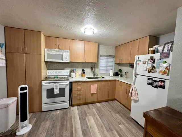 a kitchen with stainless steel appliances a stove a sink and white cabinets