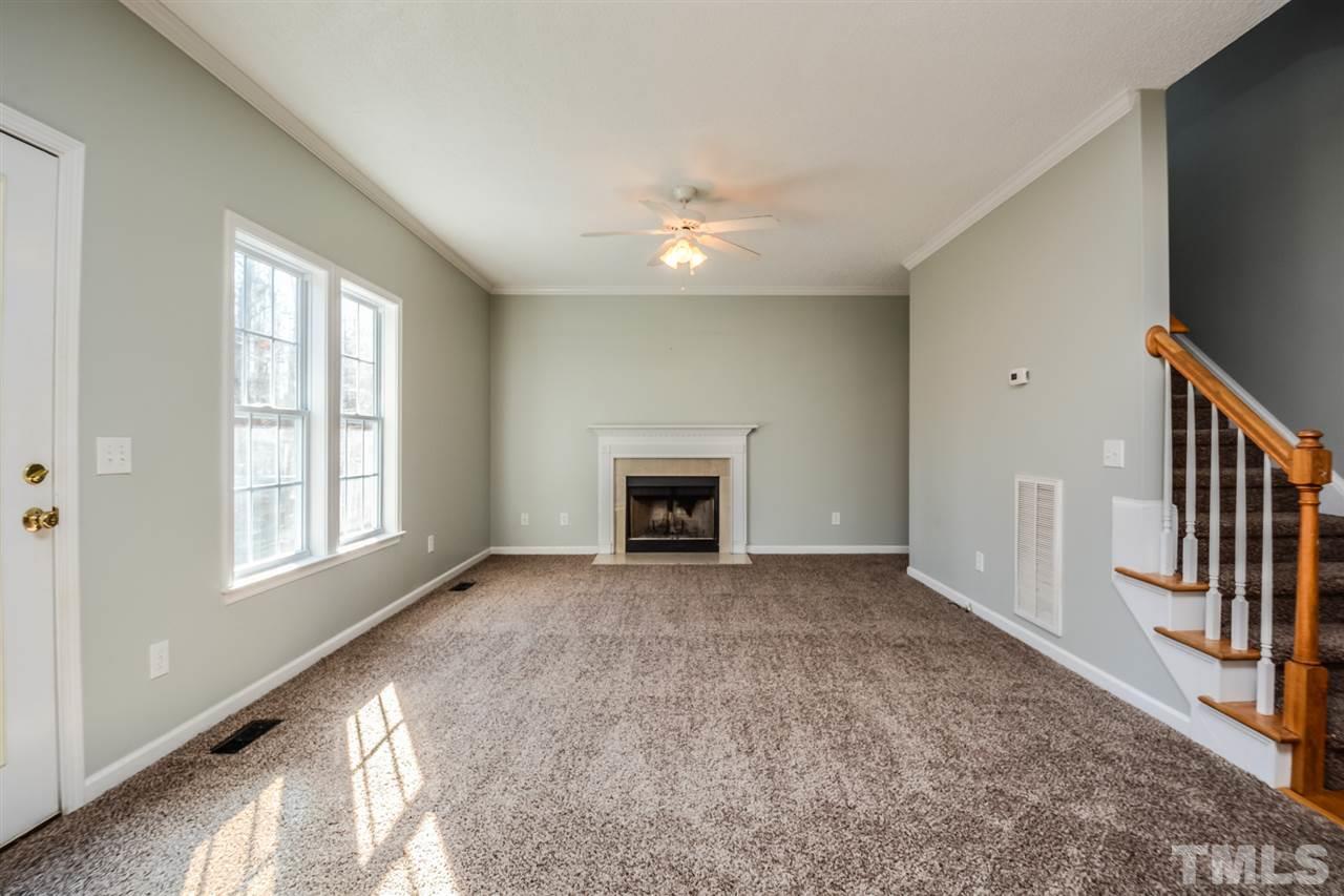 8413 Ridgebury Road Raleigh, NC 27603 - Photo 3 of 18 a view of an empty room with a fireplace and a window