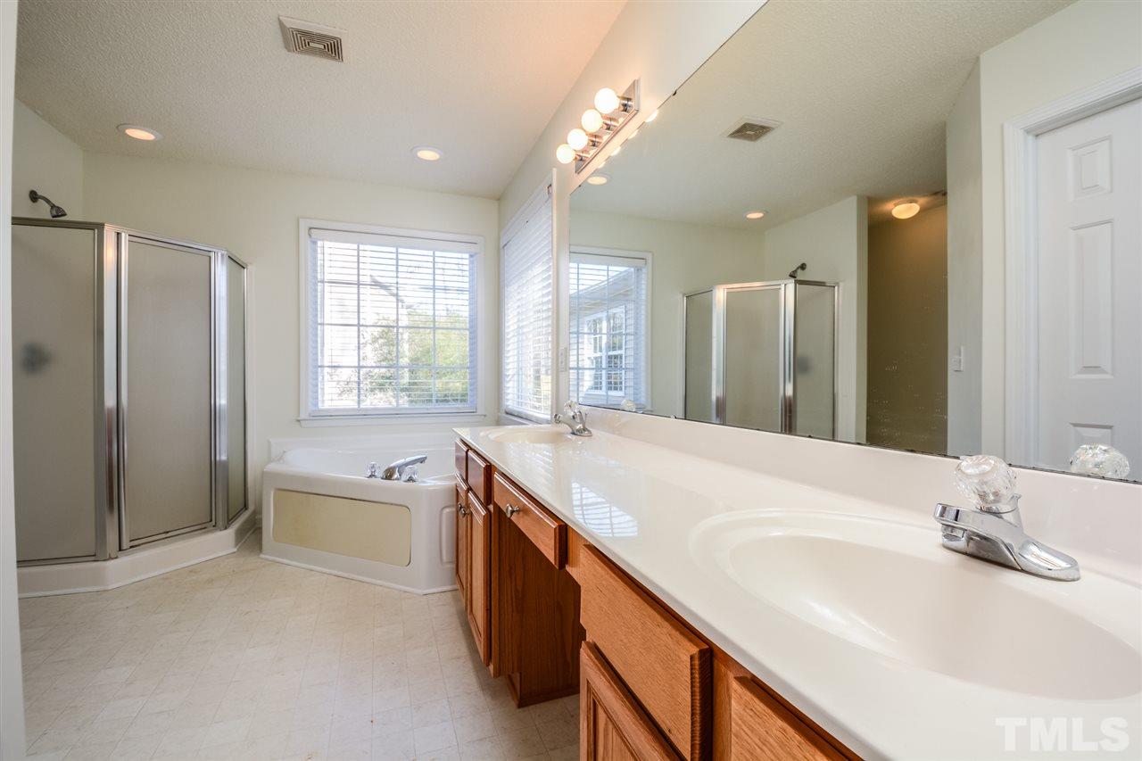8413 Ridgebury Road Raleigh, NC 27603 - Photo 4 of 18 a bathroom with a granite countertop sink mirror and a bathtub