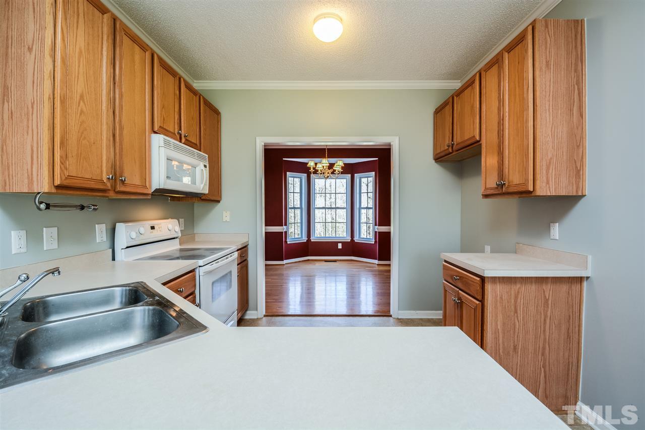 8413 Ridgebury Road Raleigh, NC 27603 - Photo 6 of 18 a kitchen with stainless steel appliances granite countertop a sink and a stove with wooden cabinets