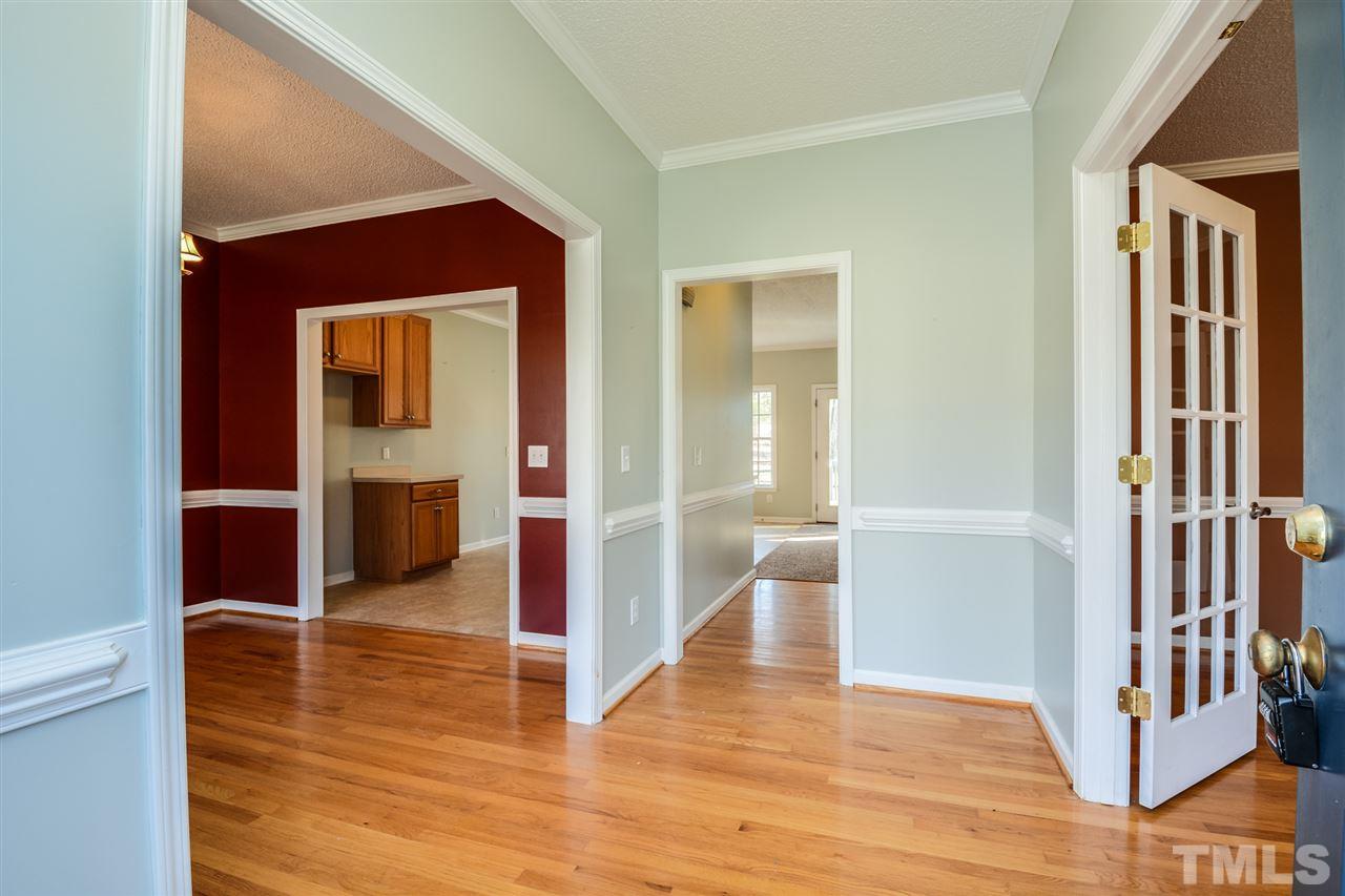 8413 Ridgebury Road Raleigh, NC 27603 - Photo 7 of 18 a view of a hallway with wooden floor and staircase