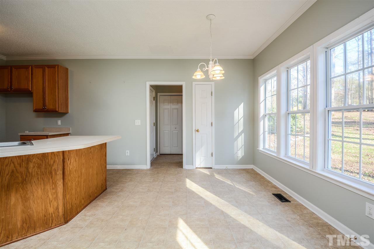 8413 Ridgebury Road Raleigh, NC 27603 - Photo 8 of 18 a view of a kitchen with a sink and dishwasher cabinet with wooden floor