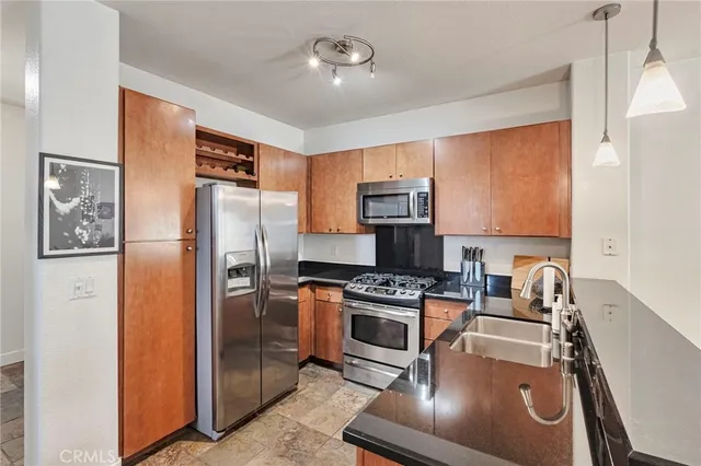 a kitchen with stainless steel appliances granite countertop a refrigerator stove and sink