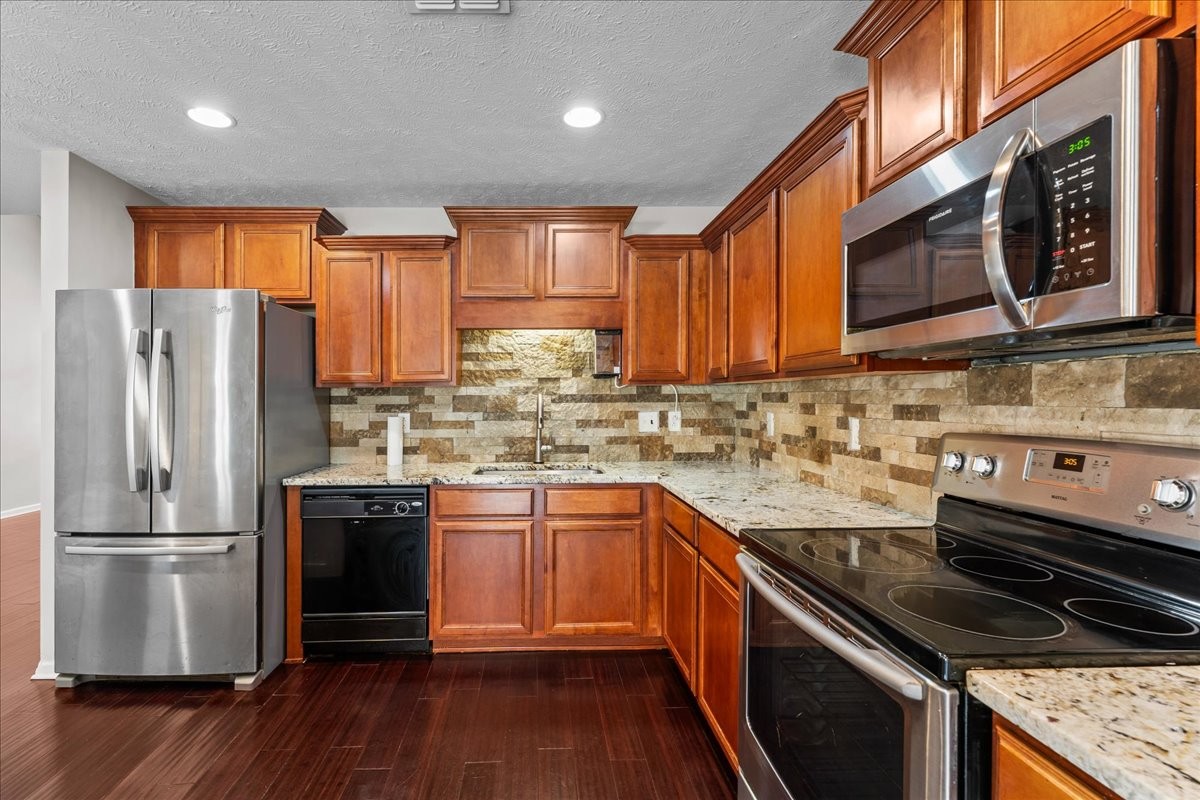 905 Thunder Gulch Way Murfreesboro, TN 37128 - Photo 11 of 27 a kitchen with stainless steel appliances granite countertop a refrigerator a sink dishwasher a stove and white cabinets with wooden floor