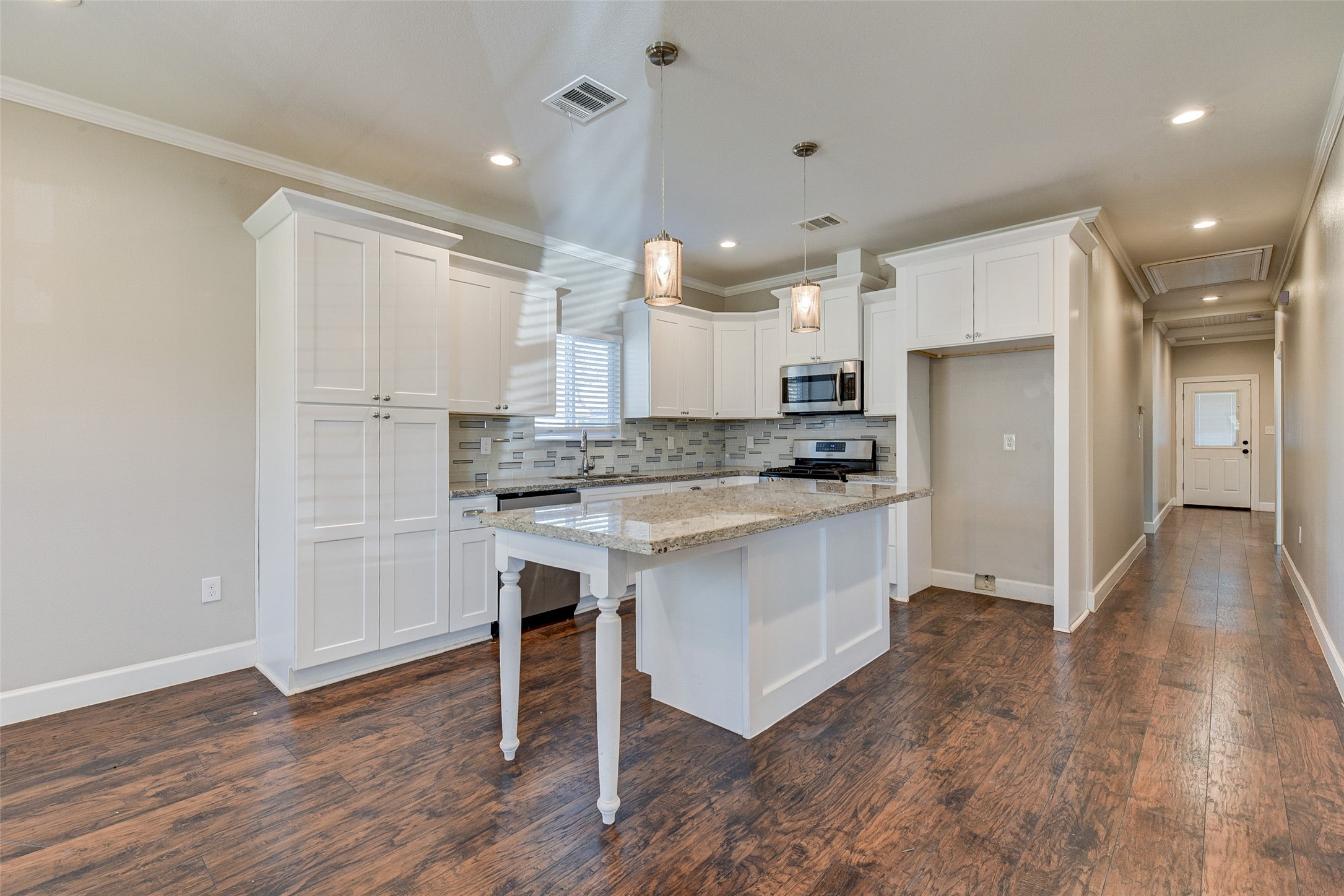 8617 Dosia Street Houston, TX 77051 - Photo 8 of 20 a kitchen with kitchen island a white counter top space a refrigerator cabinets and a fireplace