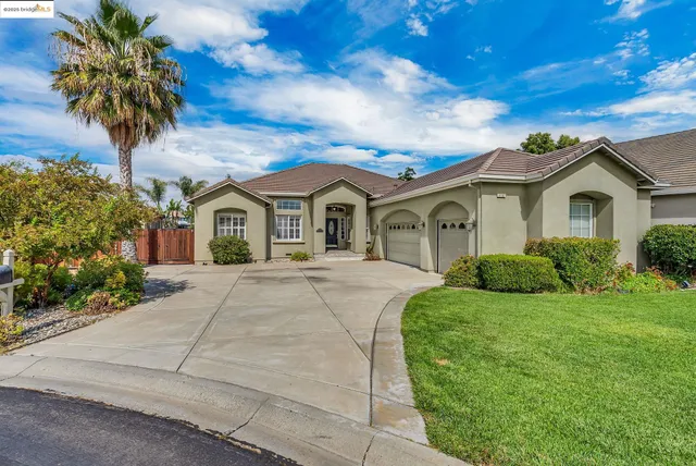 a front view of a house with a yard and potted plants