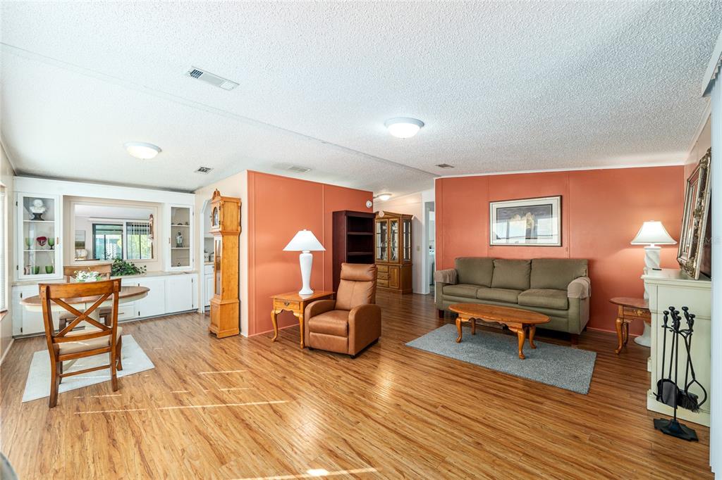 10085 Southeast 126th Place Belleview, FL 34420 - Photo 12 of 45 a living room with furniture a dining table and wooden floor