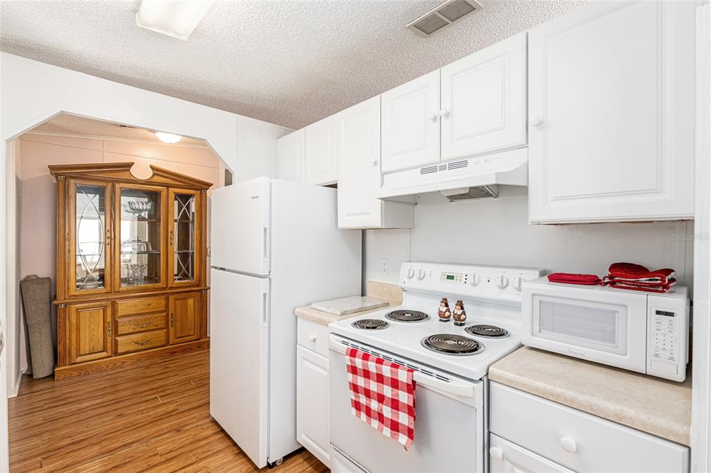 10085 Southeast 126th Place Belleview, FL 34420 - Photo 17 of 45 a kitchen with stainless steel appliances granite countertop a stove a refrigerator and a white cabinets