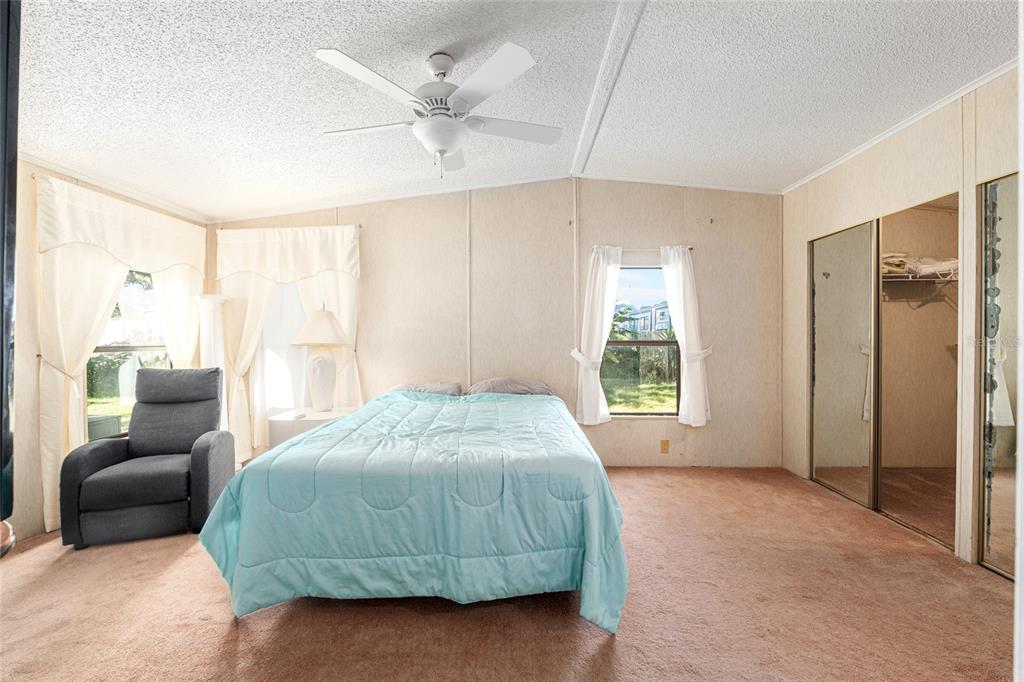 10085 Southeast 126th Place Belleview, FL 34420 - Photo 21 of 45 a spacious bedroom with a bed a couch and a large window