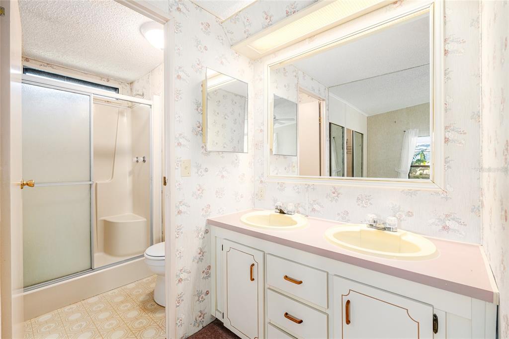 10085 Southeast 126th Place Belleview, FL 34420 - Photo 25 of 45 a bathroom with a granite countertop sink toilet mirror vanity and shower