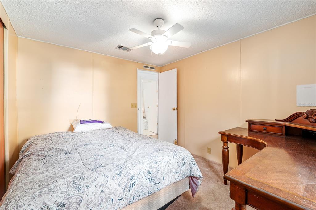 10085 Southeast 126th Place Belleview, FL 34420 - Photo 28 of 45 a bedroom with a bed and a chandelier