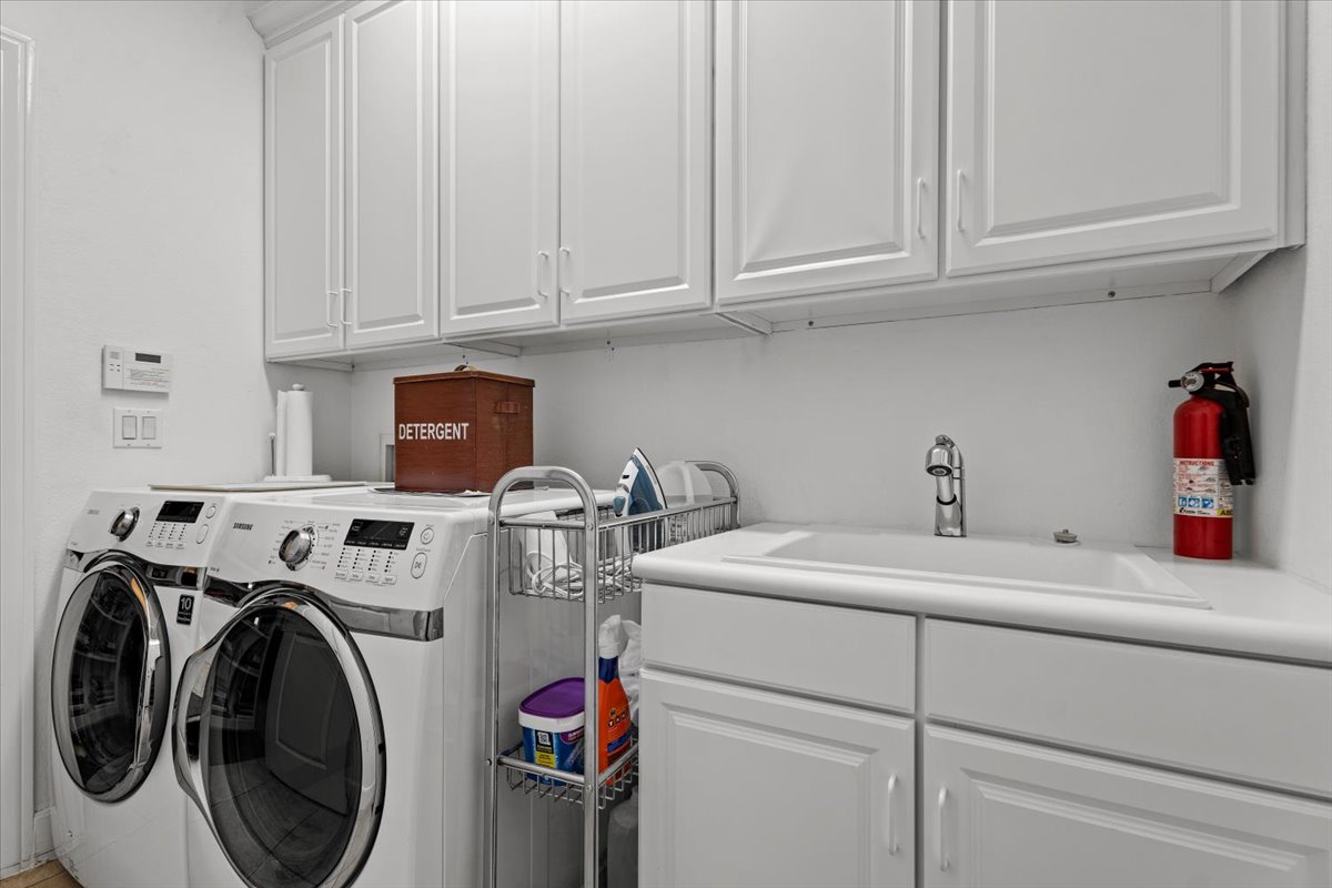 503 Breezeway Lane Georgetown, TX 78633 - Photo 31 of 38 Dedicated laundry room with built-in cabinetry, utility sink, and additional storage space to keep things organized and functional.