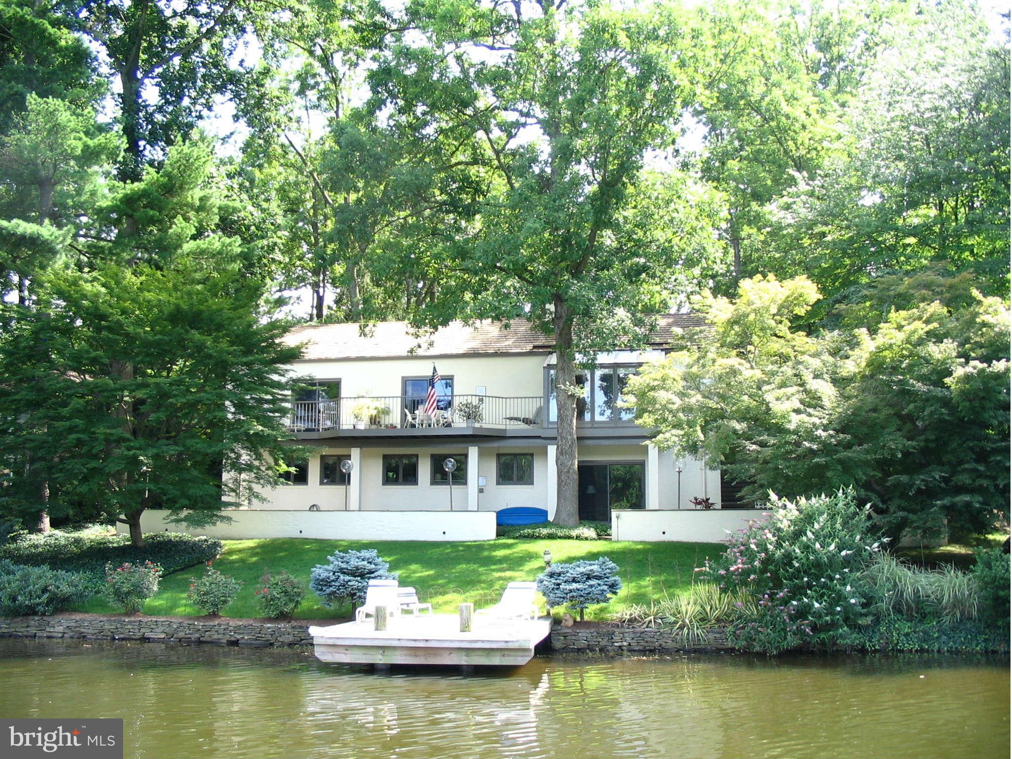 a front view of a house with a garden and trees in it