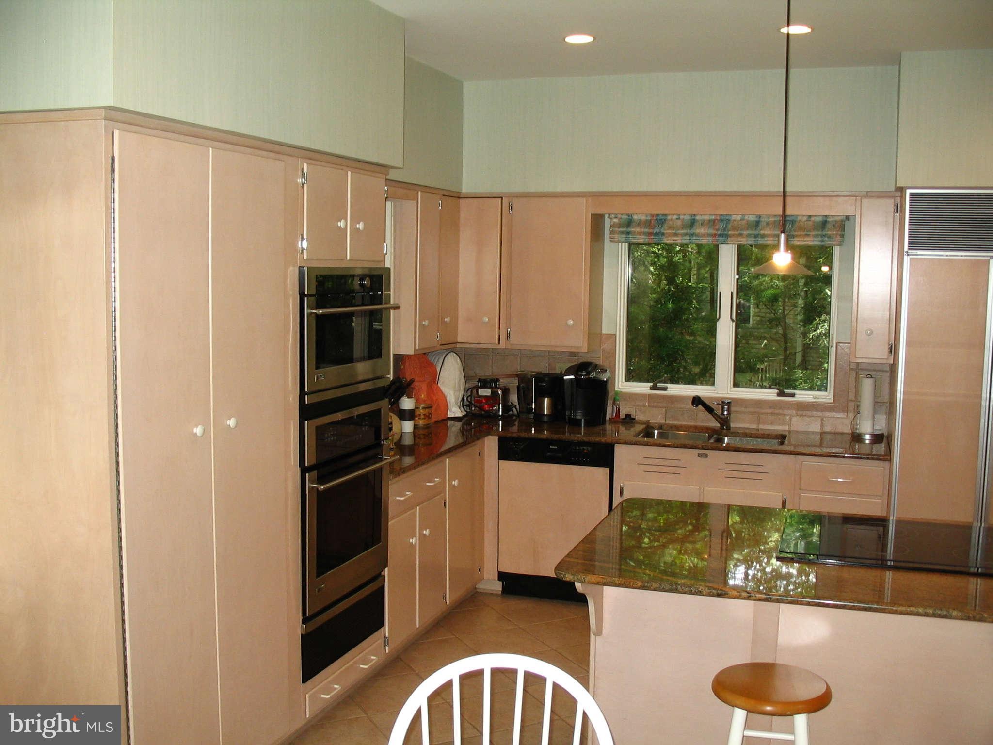 11312 South Shore Road Reston, VA 20190 - Photo 7 of 30 a kitchen with stainless steel appliances granite countertop a stove a sink and a refrigerator