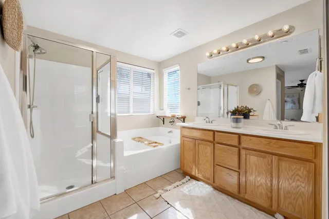a spacious bathroom with a tub sink shower and mirror