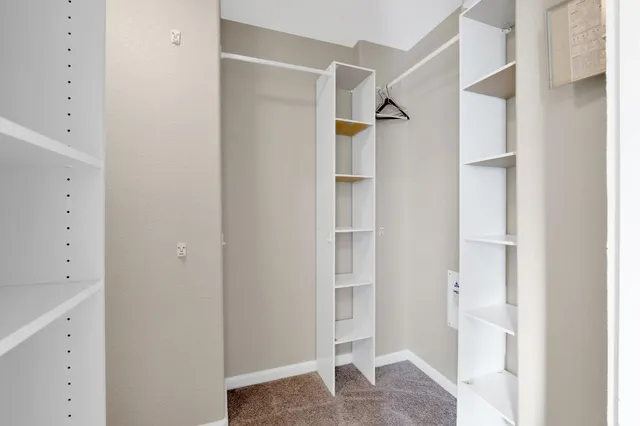 a view of walk in closet with white walls