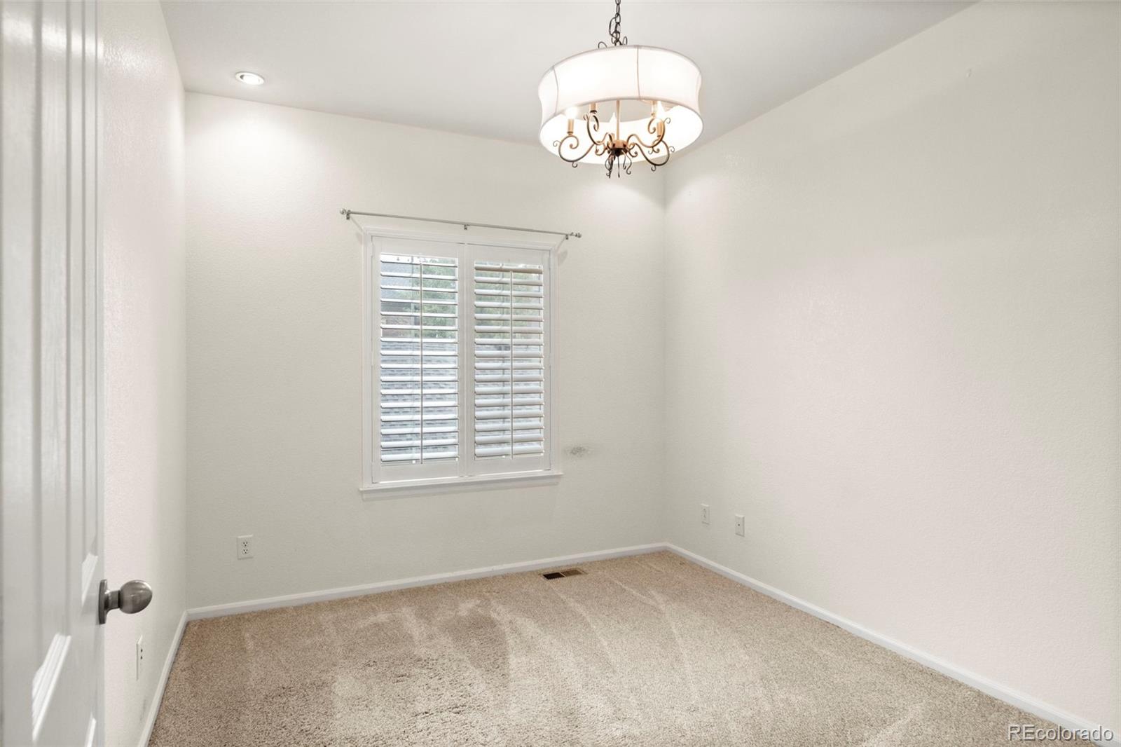 592 Brookhurst Avenue, Unit 26C Highlands Ranch, CO 80129 - Photo 26 of 30 an empty room with a chandelier fan and a window