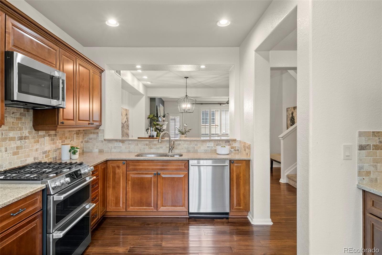 592 Brookhurst Avenue, Unit 26C Highlands Ranch, CO 80129 - Photo 6 of 30 a kitchen with stainless steel appliances granite countertop a stove a sink and a microwave