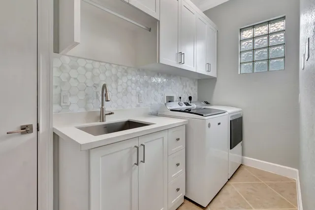 a utility room with cabinets washer and dryer
