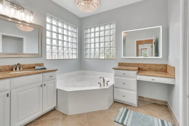 a bathroom with a tub a sink and a window