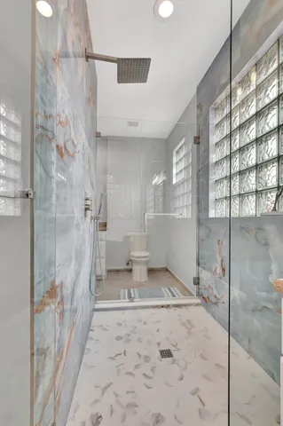 a bathroom with a granite countertop toilet sink and mirror