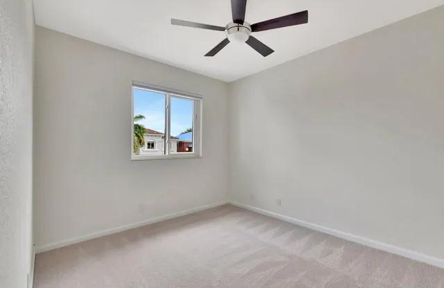 wooden floor in an empty room and a ceiling fan