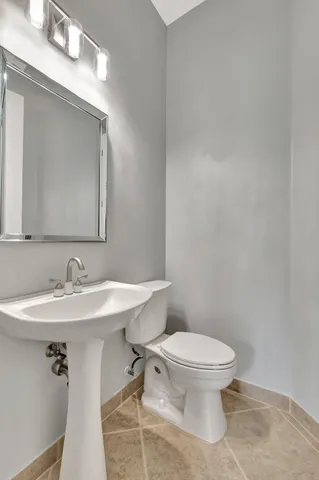 a bathroom with a toilet a sink and mirror