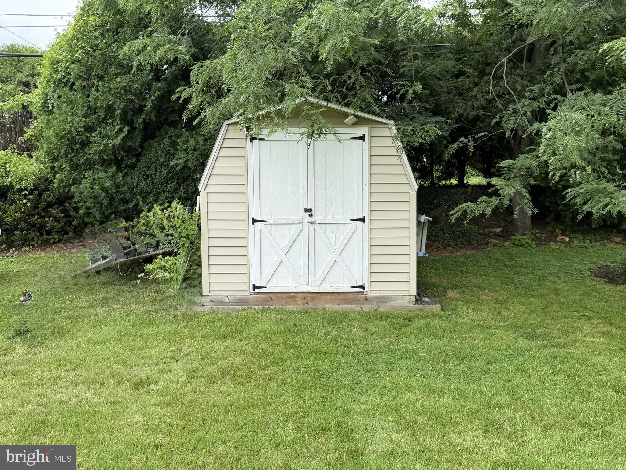 217 Lyster Road Oreland, PA 19075 - Photo 8 of 11 Charming garden shed nestled in greenery.