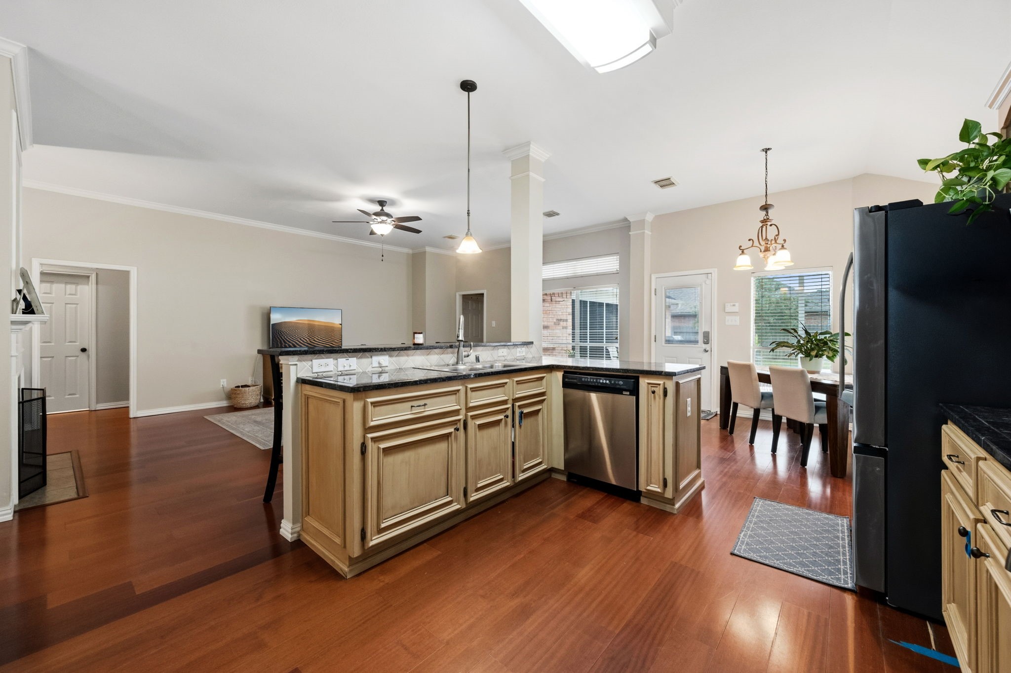 7514 Tumbling Road Humble, TX 77346 - Photo 13 of 28 a kitchen with stainless steel appliances granite countertop a refrigerator a sink dishwasher a stove and a dining table with wooden floor