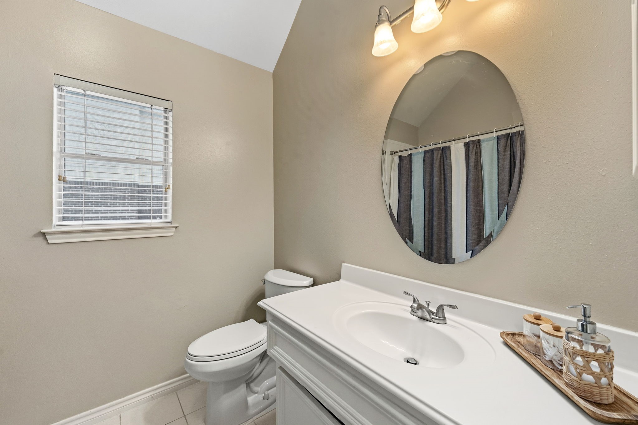 7514 Tumbling Road Humble, TX 77346 - Photo 20 of 28 a bathroom with a toilet a sink and mirror