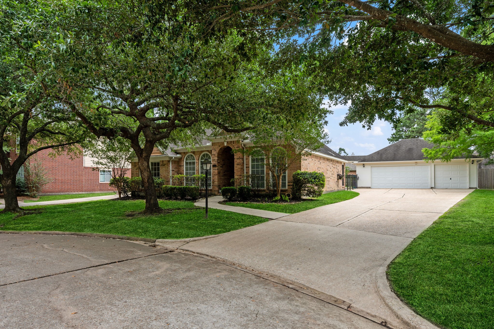 7514 Tumbling Road Humble, TX 77346 - Photo 2 of 28 a front view of a house with a garden and trees