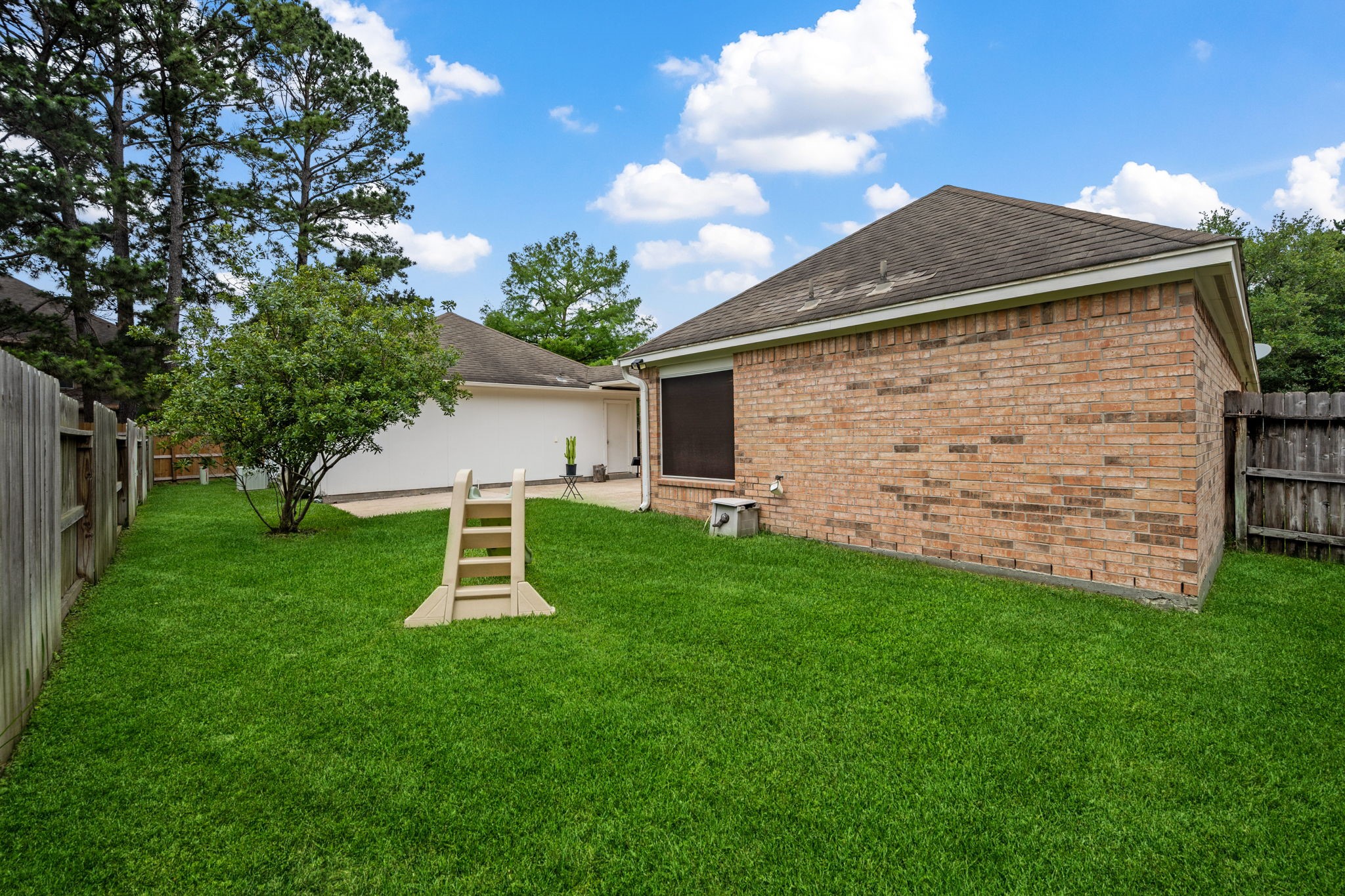 7514 Tumbling Road Humble, TX 77346 - Photo 26 of 28 a view of a backyard with plants and a large tree